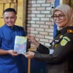 Kejari Pelalawan Silpia Rosalina memberikan Kenangan Buku secara simbolis kepada Ketua JMSI Pelalawan, Erik Suhendra