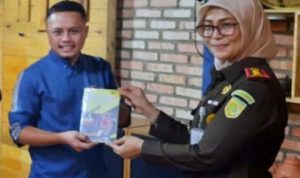 Kejari Pelalawan Silpia Rosalina memberikan Kenangan Buku secara simbolis kepada Ketua JMSI Pelalawan, Erik Suhendra