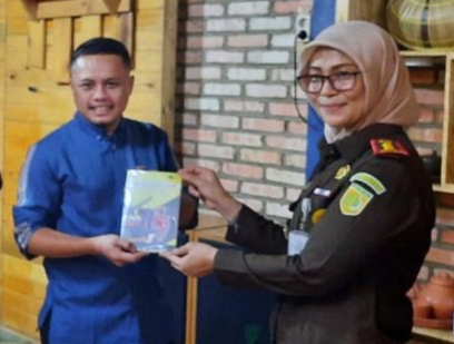 Kejari Pelalawan Silpia Rosalina memberikan Kenangan Buku secara simbolis kepada Ketua JMSI Pelalawan, Erik Suhendra